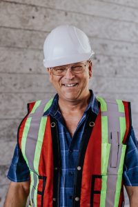 Profile picture of one of the Kelco Drywall employees, he is wearing a helmet as well as a safety vest.